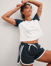 white relaxed fit, waist length t-shirt with colorblock raglan sleeve and neck binding.